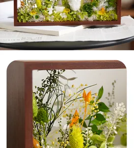 Vue détail fleurs séchées conservées cadre photo creux en bois massif décoration maison.