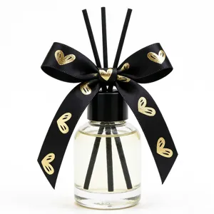 Difusor de aroma para el hogar con cinta negra de corazones y varillas de bambú.