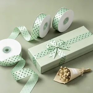 Detailed view of elegant sage green polka dot ribbon rolls and beautifully wrapped gift box display.