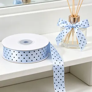 Light blue polka dot satin ribbon roll for gift wrapping, floral bouquets, and DIY crafts.