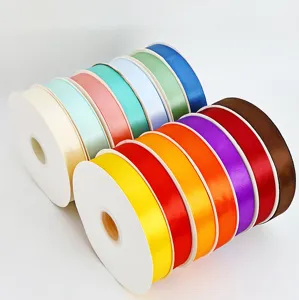 Detailed view of colorful 2.5cm polyester satin ribbon rolls for gift and cake box.