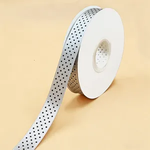 Vista dettagliata di un nastro argentato a pois per confezioni regalo e decorazioni.