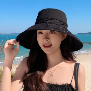 Stylish black women bucket hat with rhinestones and bow, perfect for summer beach travel.