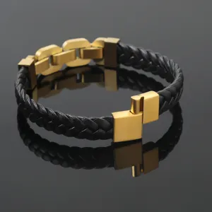 Detail of a braided black leather bracelet with a gold-tone stainless steel magnetic clasp.