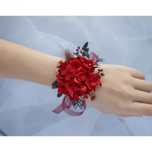 Close-up detail of the elegant red preserved flower wrist corsage worn on hand for wedding.