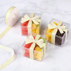 Gedetailleerd overzicht van doorzichtige fruitgeschenkdozen met mooie gele decoratieve linten.