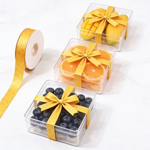 Transparante fruitcadeaueldoos met gele lintdetails, ideaal voor bloemisten en decoratie.