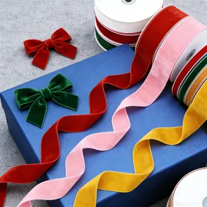 Close up of colorful velvet ribbons and bows arranged on blue box for gift decoration detail.