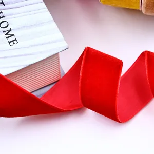 Red velvet ribbon detail shot, soft flocked texture for gift wrapping and hair accessories.