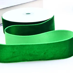 Close-up detail of green velvet ribbon roll and texture showing smooth fabric quality.