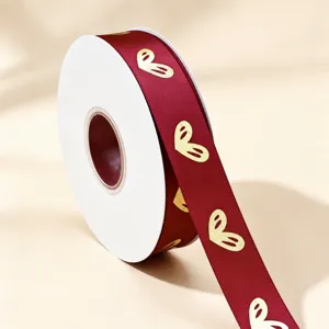 Red satin ribbon with gold foil heart pattern, roll packaging for gift box decoration.