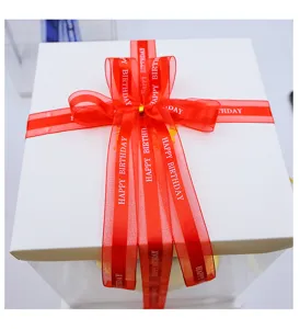 Detailed close-up of red Happy Birthday ribbon bow on a white gift box packaging.