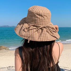 Détail de vue arrière du chapeau de soleil élégant à carreaux marron à large bord.