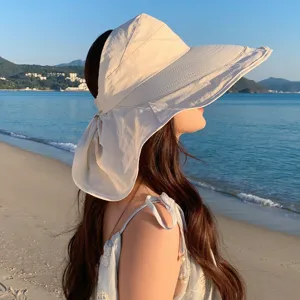Detailansicht des beigen Sonnenhutes mit breiter Krempe und Nackenschutz für Strand Sommer.