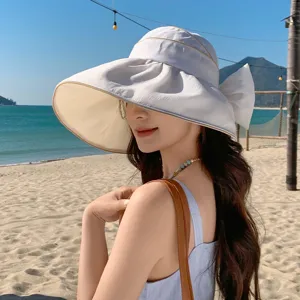 Stranddetail zeigt Sonnenhut mit breiter Krempe und eleganter Schleife für Damen.