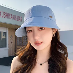 Dettagli dell'elegante cappello da sole azzurro con stemma in metallo e protezione solare.