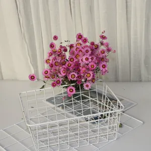 Close up detail of dried flowers bouquet arranged inside a white wire storage basket.