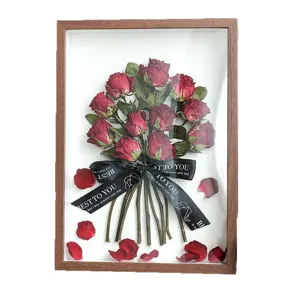 Prachtige decoratieve houten lijst met rode rozen en droogbloemen als romantisch geschenk.