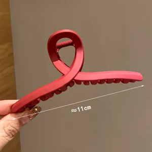 Λεπτομέρεια από κόκκινο ματ κλιπ μαλλιών, μεγάλο κομψό γεωμετρικό αξεσουάρ για γυναίκες.
