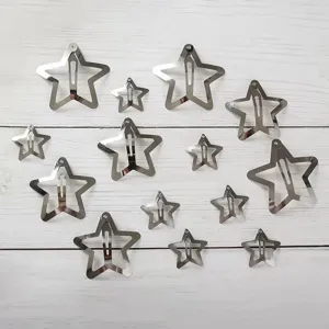 Detail shot of metallic star hair clips in mixed sizes, Y2K style aesthetic accessories.