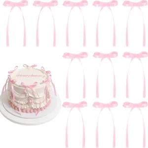 Pink ribbon bow cake toppers with long streamers for birthday wedding party decor detail