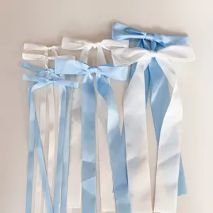 Dettaglio di splendidi fiocchi in nastro di raso blu e bianco con code per decorazione.