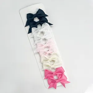 Close-up detail shot of colorful ribbon bow hair clips set on display card, sweet style.
