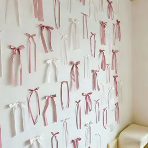 Nastri decorativi da parete in raso rosa e bianco, ideali per sfondi fotografici.