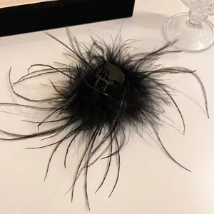 Close-up detail of fluffy black ostrich feather hair claw clip for elegant hairstyles.