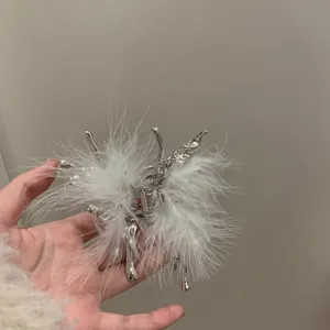 Silver liquid butterfly hair claw clip featuring fluffy white feathers for trendy styling.
