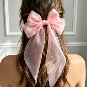 Λεπτομερής λήψη μιας κομψής ροζ διάφανης φιόγκας τσιμπιδάκι μαλλιών με μακριές κορδέλες.