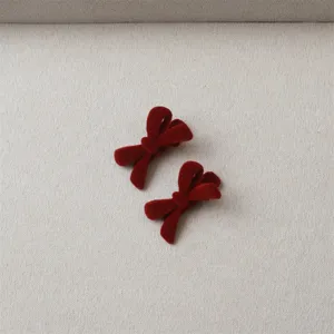 Detail view of red velvet bow hair clips, soft flocked texture design, side clip accessory.