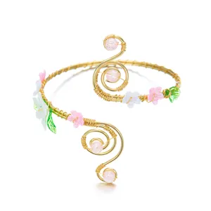 Vista dettagliata del bracciale da braccio in filo dorato con fiori e perline rosa