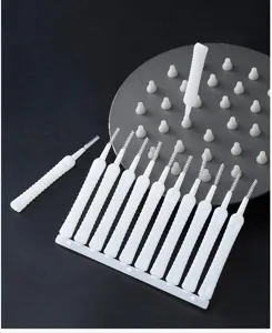 Detailed view of white mini shower hole cleaning brushes showing fine bristles and molded plastic frame.