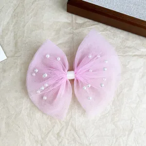 Detailed close-up of a pink mesh pearl bow hairpin, elegant design with delicate faux pearls.