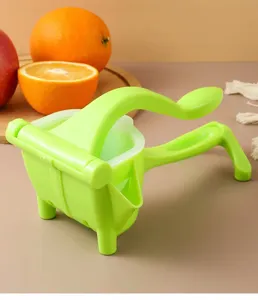 Vue de détail du presse-citron manuel en plastique vert avec poignée ergonomique et bec verseur.
