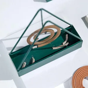 Detailopname van de groen metalen piramide muggenwierehouder met textuur en asbakontwerp.