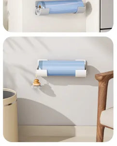 Detail view of wall mounted kitchen storage rack holding plastic wrap roll and cleaning brush.