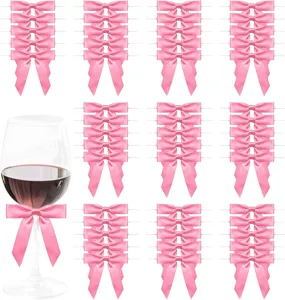 Detail view of pink ribbon bows for gift wrapping, showing decorative use on wine glass.