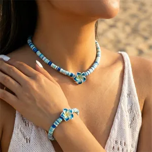 Halsketten- und Armband-Set mit blau-weißen Plumeria-Blüten aus Fimo am Modell.