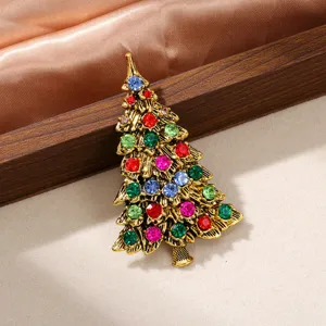 Gros plan détaillé d'une broche sapin de Noël vintage dorée avec strass colorés brillants