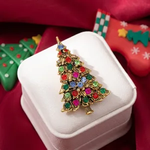 Vue détaillée d'une broche sapin de Noël dorée avec des strass multicolores.