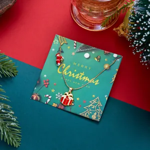 Dettaglio di una collana natalizia dorata con ciondolo a pacco regalo e Babbo Natale