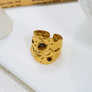 Close-up detail of irregular lava texture gold ring with brown tiger's eye stones