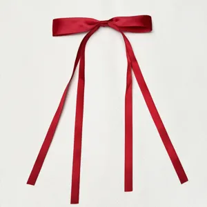 Close-up view of a wine red satin ribbon bow with long hanging tails, smooth fabric detail.
