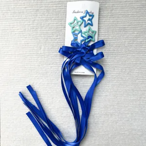 Vista dettagliata delle mollette per capelli a stella e nastri blu, accessori graziosi.