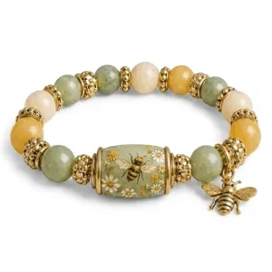 Detail view of a vintage crystal bracelet with a gold bee charm and floral bead.