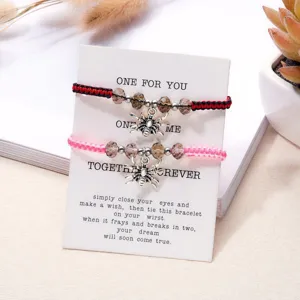 Makroaufnahme von handgefertigten Spinne-Armbändern auf einer weißen Wunschkarte.