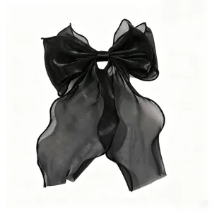 Close-up detail of an elegant black sheer organza hair bow with shimmering glitter ribbon.
