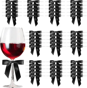 Detail view of black satin bows and wine glass scene for party gift packaging decor.